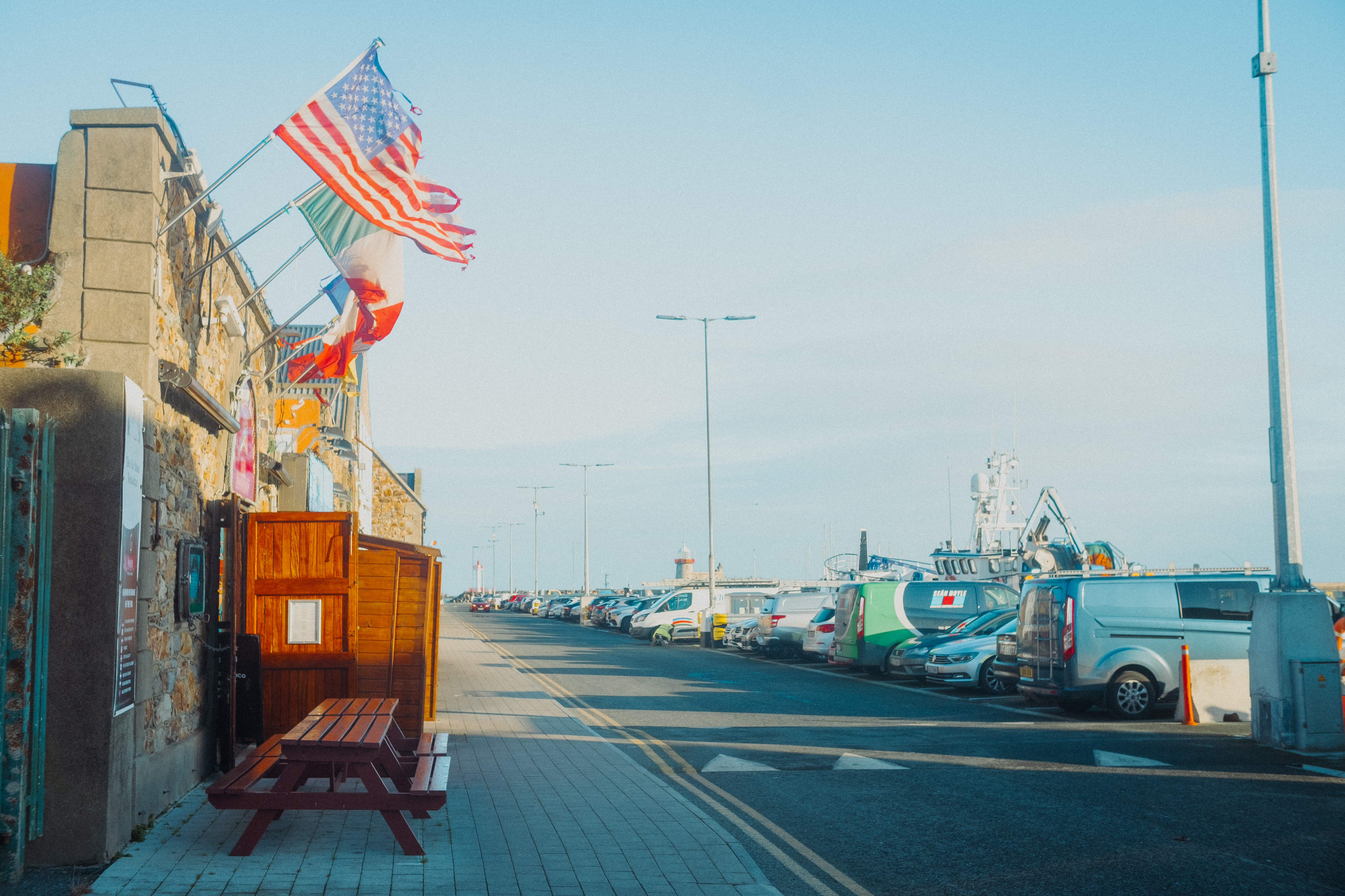 Seaside harbor street with colorful flags and a warm glow